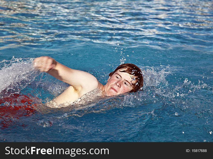 Young boy is crawling in the pool