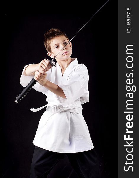 Young boy concentrated training in karate with a sword. Young boy concentrated training in karate with a sword
