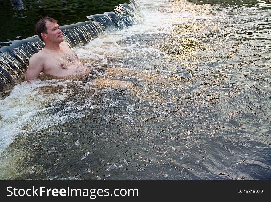 Man sitting in nature spa water