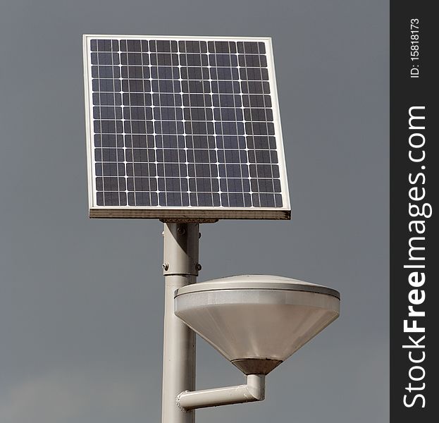 Solar powered street light against a stormy sky