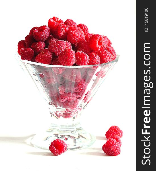 A red raspberry is in glass
