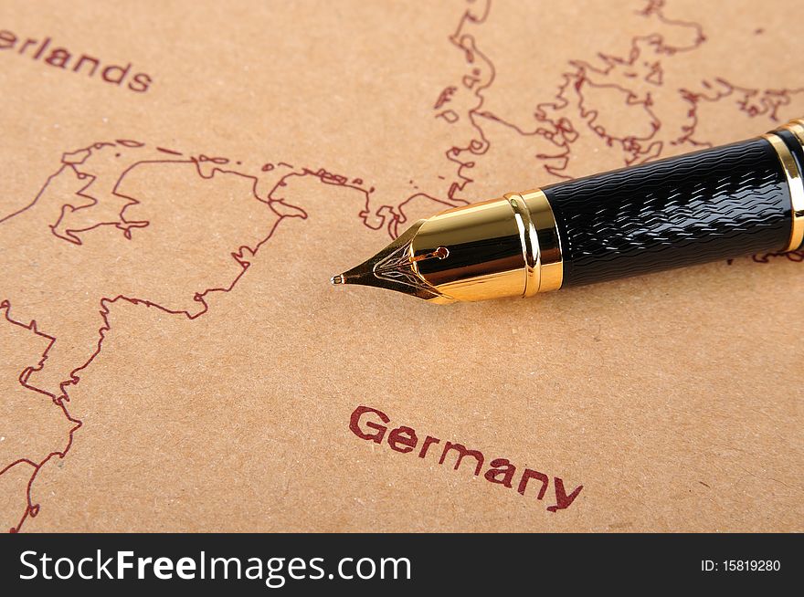 A fountain pen with golden top putting on a European map, means business and travel concept. A fountain pen with golden top putting on a European map, means business and travel concept.