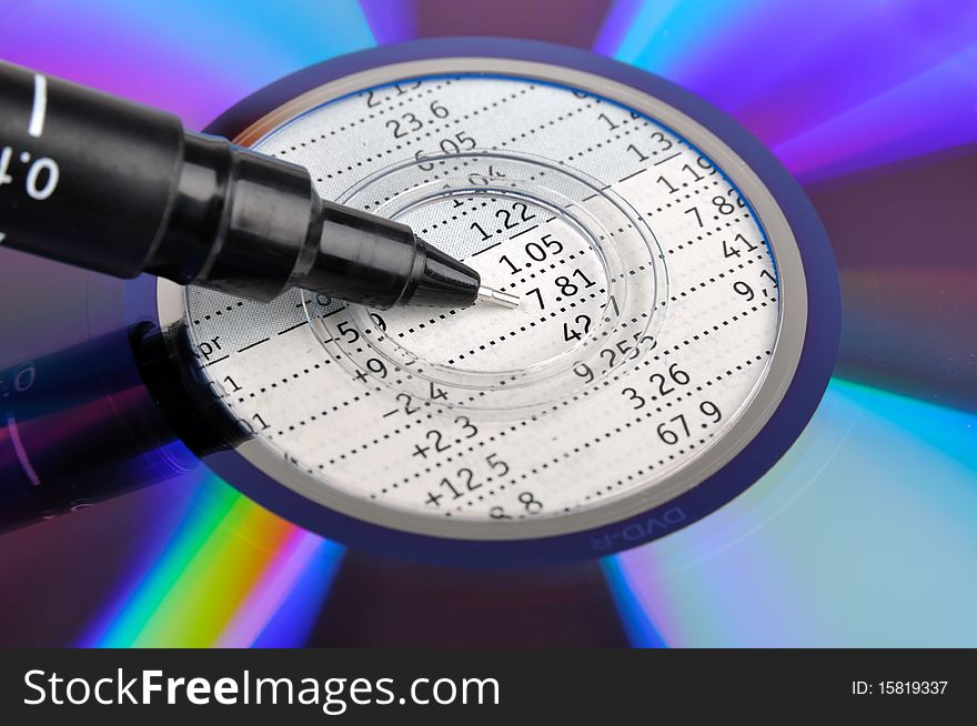 A colorful compact disk putting on a datasheet, with a pen point to center, means data and analysis business concept. A colorful compact disk putting on a datasheet, with a pen point to center, means data and analysis business concept.
