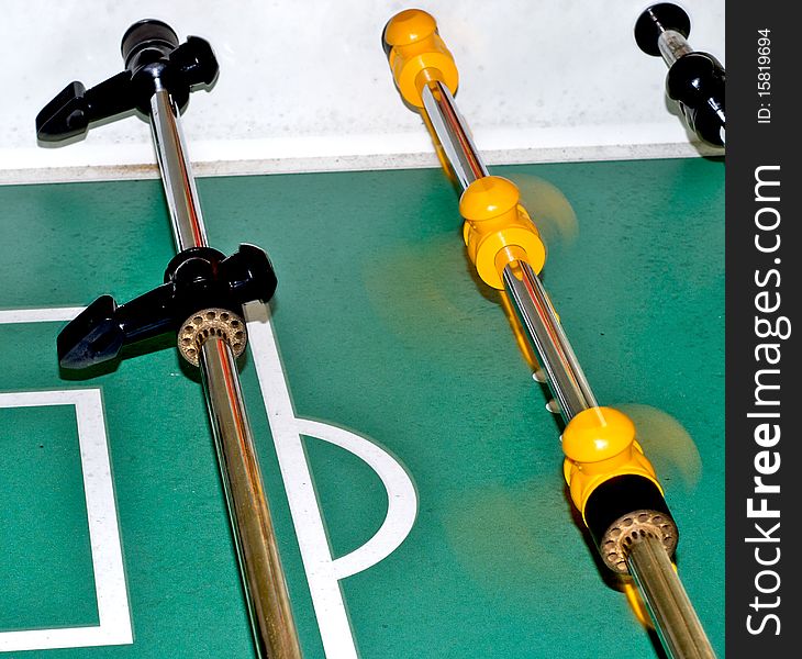 Black and yellow foosball players spinning to take a shot. Black and yellow foosball players spinning to take a shot.