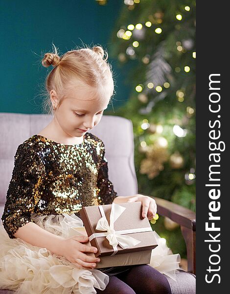 Christmas and New Year celebration concept. Pretty little girl playing and being happy about christmas tree and lights. Winter holidays. Happy family