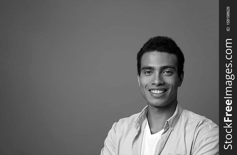Handsome young African-American man on grey background. Black and white effect