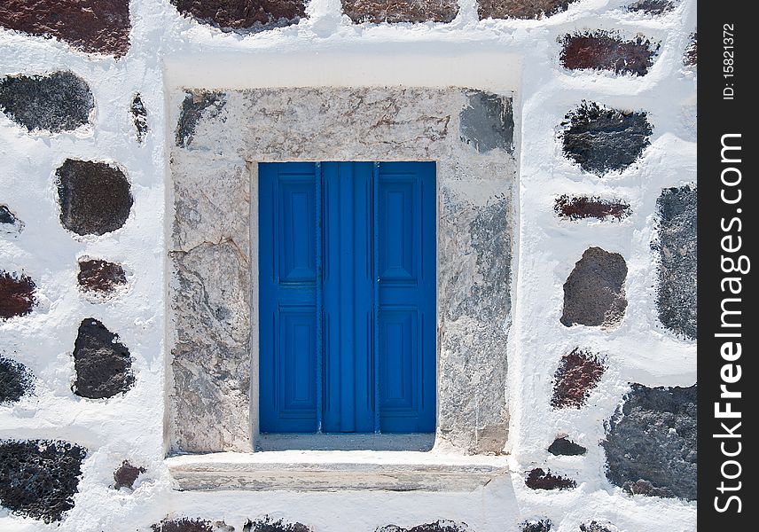 Stonewall with blue window from a house in Santorini Island. Stonewall with blue window from a house in Santorini Island