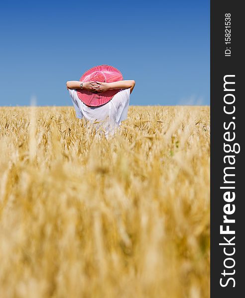 Beautiful woman with hat in wheat meadow on sunny day