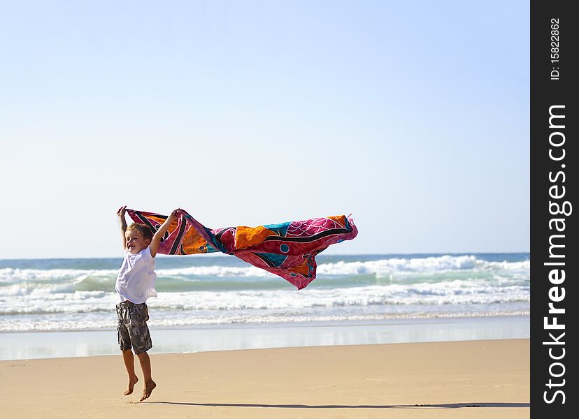 Young blonde haired boy with a sarong on the beach. Young blonde haired boy with a sarong on the beach