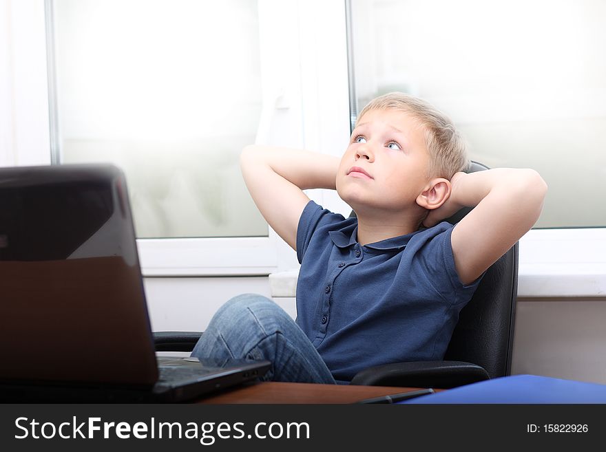 Relaxed young boy near laptop. Relaxed young boy near laptop.