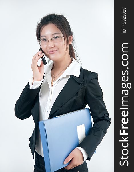 A Smiling business girl  in glasses with a cell phone and folders of documents. A Smiling business girl  in glasses with a cell phone and folders of documents