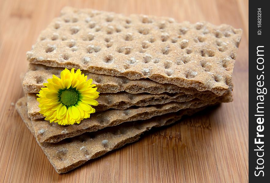 Stacked crispbread on wooden board with blossom