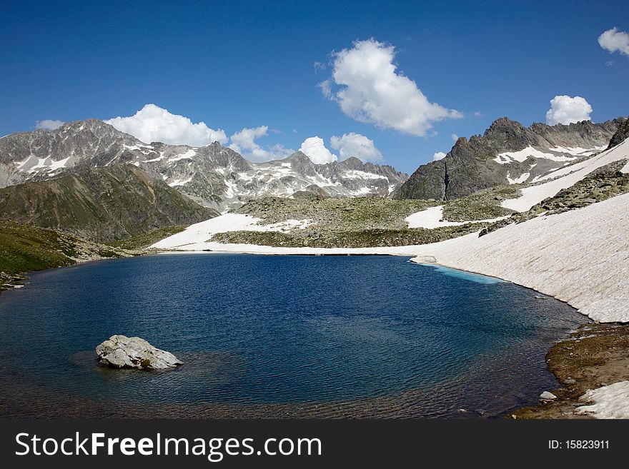 Blue lake surounded with snow and rocky mountains. Blue lake surounded with snow and rocky mountains