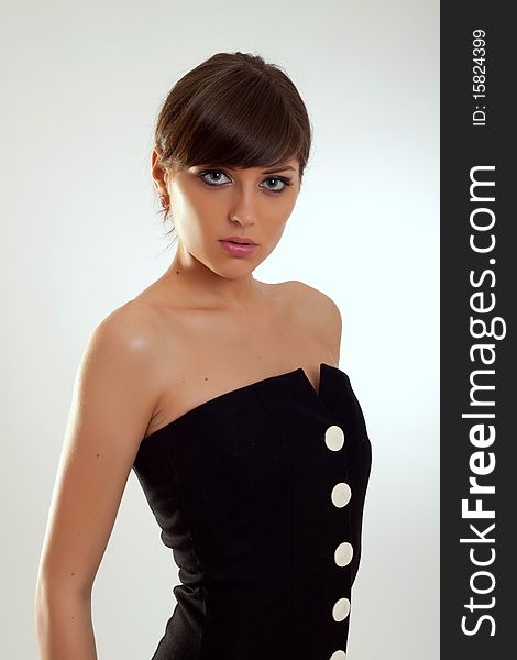 Beautiful fashion model in a black dress posing for the camera