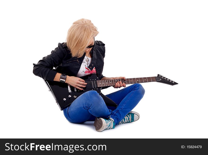 Passionate rock girl playing an electric guitar sitting down