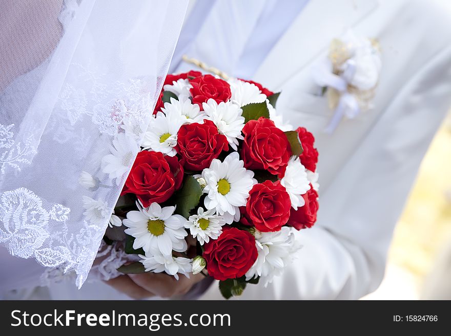 Bride holding beautiful red roses wedding flowers bouquet