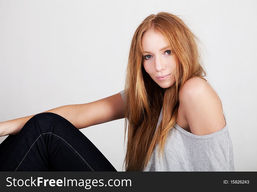 Side view of a beautiful young woman with red hair posing in stylish clothing. Horizontal shot. Side view of a beautiful young woman with red hair posing in stylish clothing. Horizontal shot.