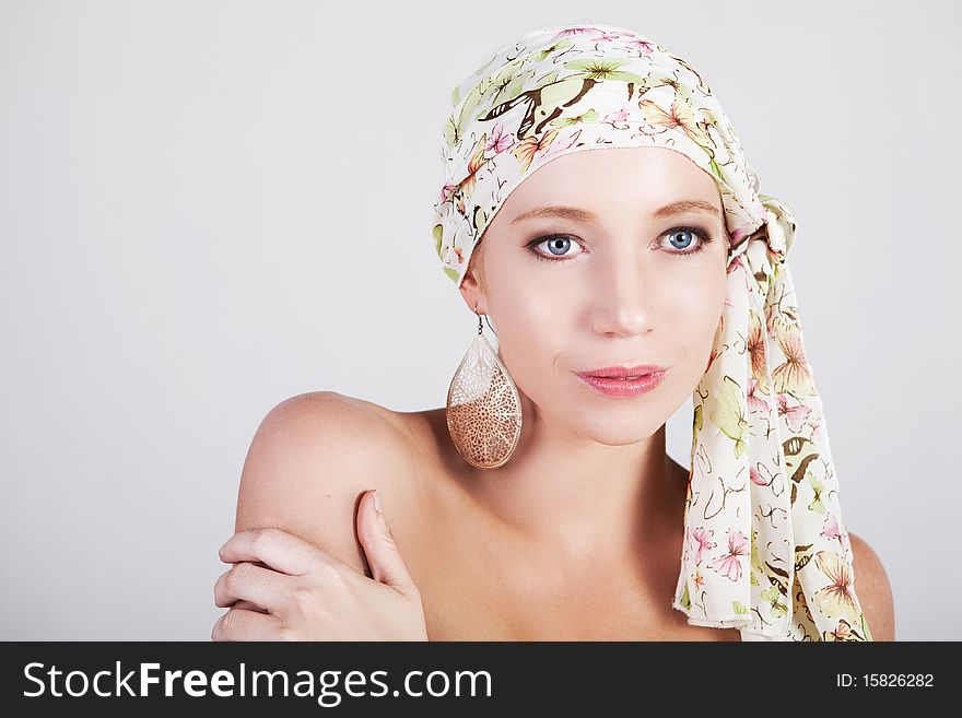 Head and shoulders portrait of an attractive young woman wearing a headscarf and ornate earrings. Horizontal shot. Head and shoulders portrait of an attractive young woman wearing a headscarf and ornate earrings. Horizontal shot.