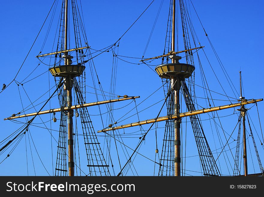 Tall ship's masts with a deep blue sky.