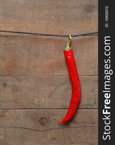 Red chili pepper hanging on wooden background with rope. Red chili pepper hanging on wooden background with rope