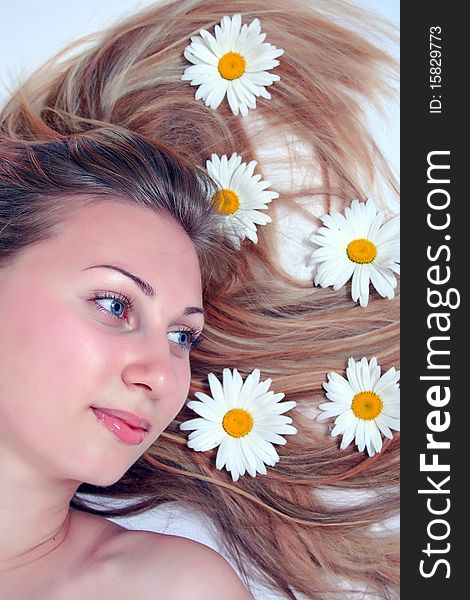 Close-up portrait of a fresh and beautiful woman with chamomile