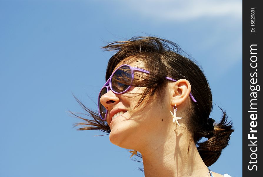 Portrait of a young woman smiling that wears sunglasses and looking somewhere far away. Portrait of a young woman smiling that wears sunglasses and looking somewhere far away