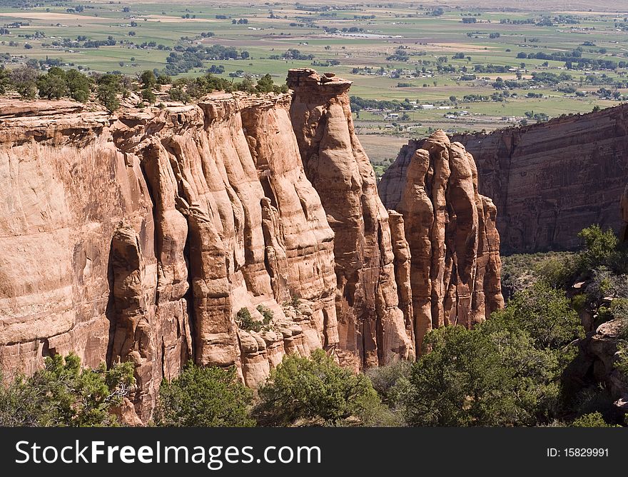 Sandstone formations along the canyon walls in Colorado National Monument with the Colorado River valley in the background.