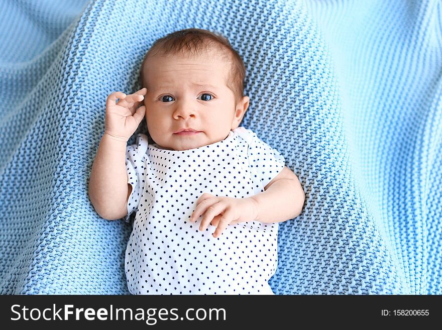 Cute little baby lying on light blue d, top view