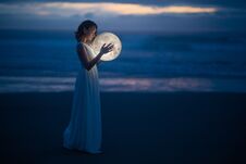 Tender Image Of A Girl. Female Magic. Beautiful Attractive Girl In Full Growth On A Night Beach With Sand Hugs The Moon, Art Photo Royalty Free Stock Image
