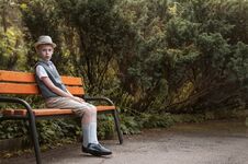 Child Sitting At  The Park Bench In The Countryside Royalty Free Stock Photos