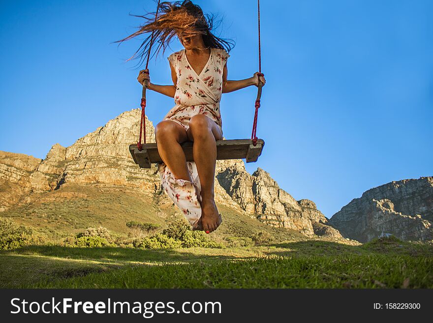 Woman on swing under Table Mountain, Camps Bay, Cape Town. Woman on swing under Table Mountain, Camps Bay, Cape Town.