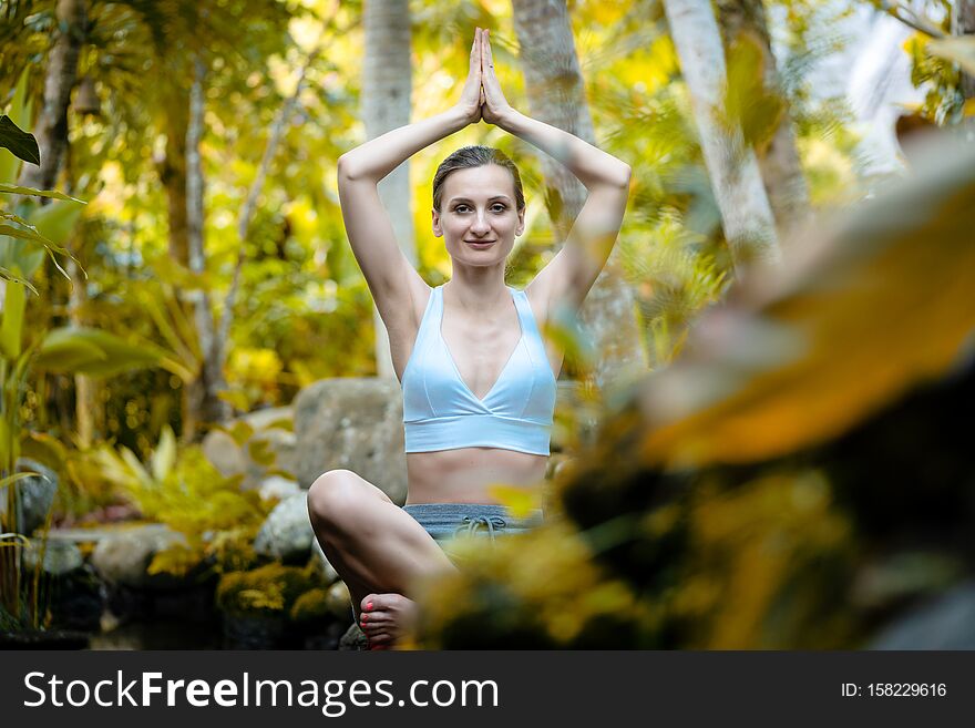 Woman doing yoga in the tropical jungle