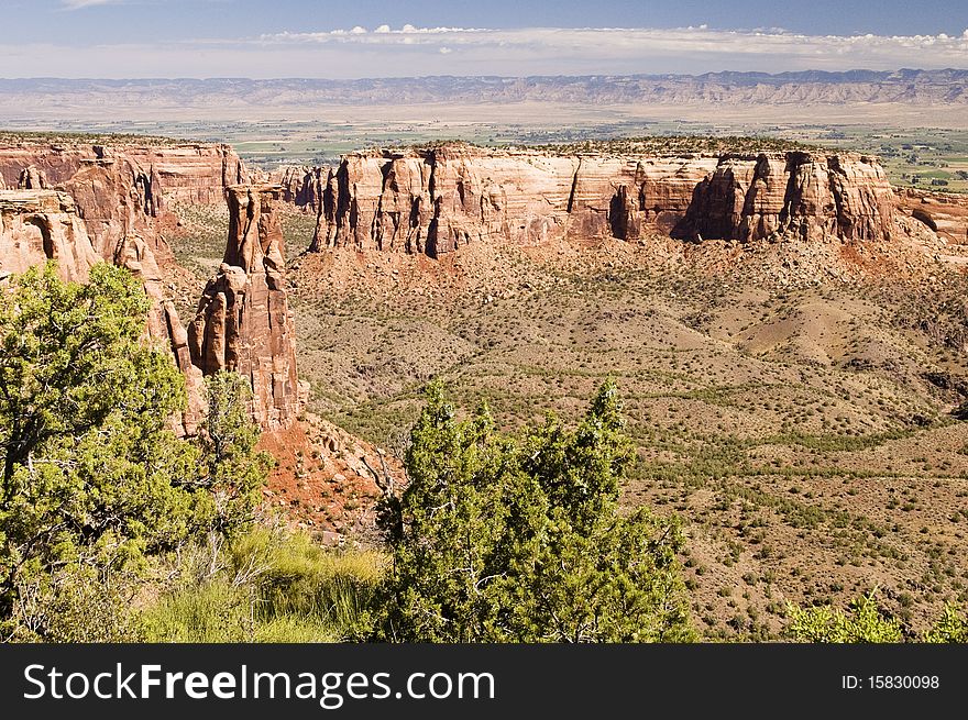 Sandstone formations along the canyon walls in Colorado National Monument with the Colorado River valley in the background.