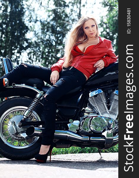 Shot of an attractive woman biker posing on her motorcycle. Shot of an attractive woman biker posing on her motorcycle.