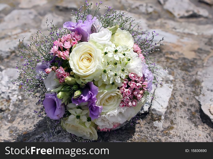 Colorful wedding Bouquet of Field Flowers on the stone wall