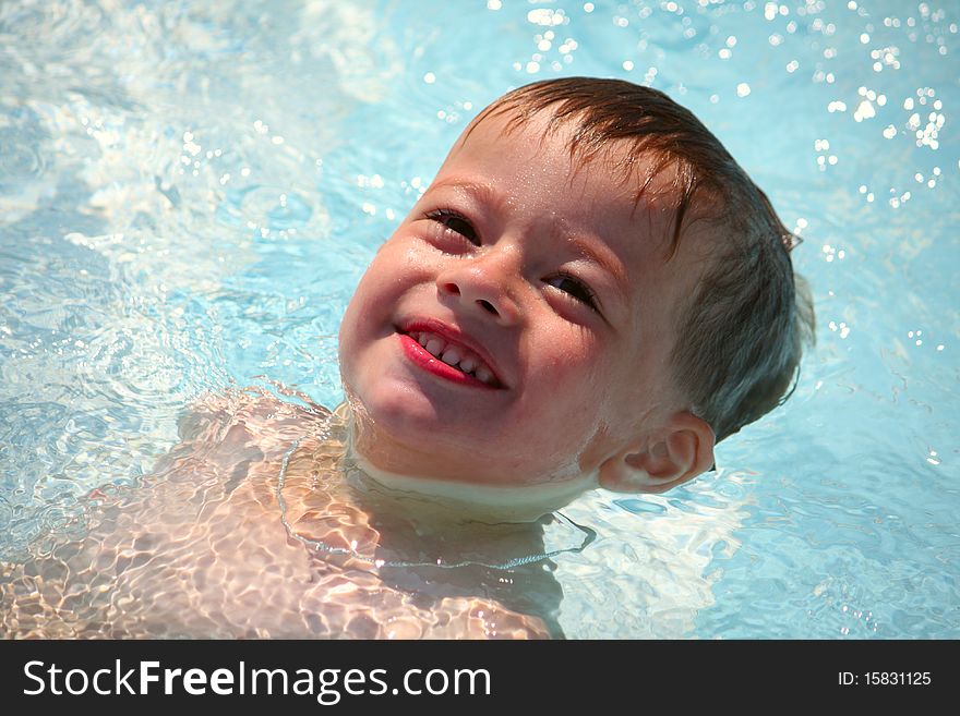 The happy little boy swims in pool. The happy little boy swims in pool