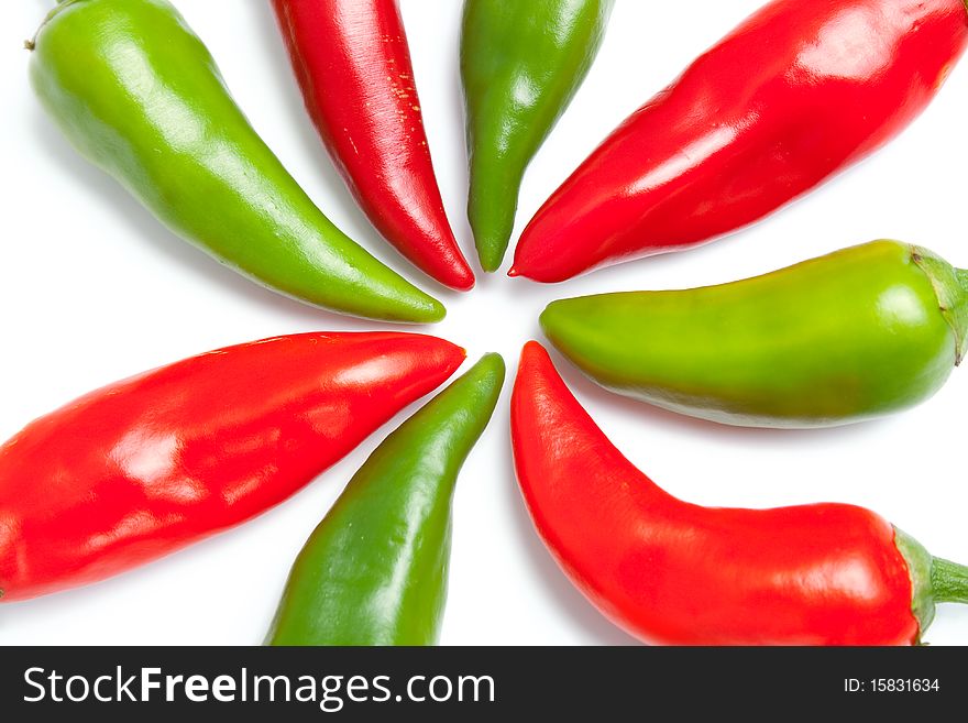 Green and red hot peppers close up arranged in shape of sun rays isolated on white background. Green and red hot peppers close up arranged in shape of sun rays isolated on white background