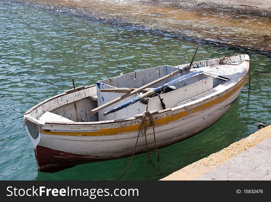 A battered rowing boat moored in Capri's harbour. A battered rowing boat moored in Capri's harbour