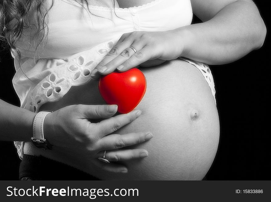Pregnant woman holding red heat in her hand separated by color. Pregnant woman holding red heat in her hand separated by color