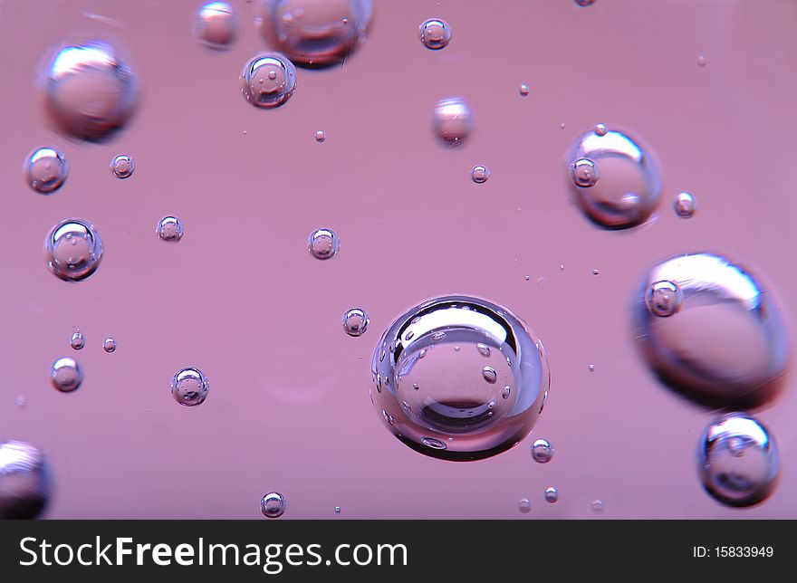 Bubbles of different sizes floating in pink liquid. Bubbles of different sizes floating in pink liquid