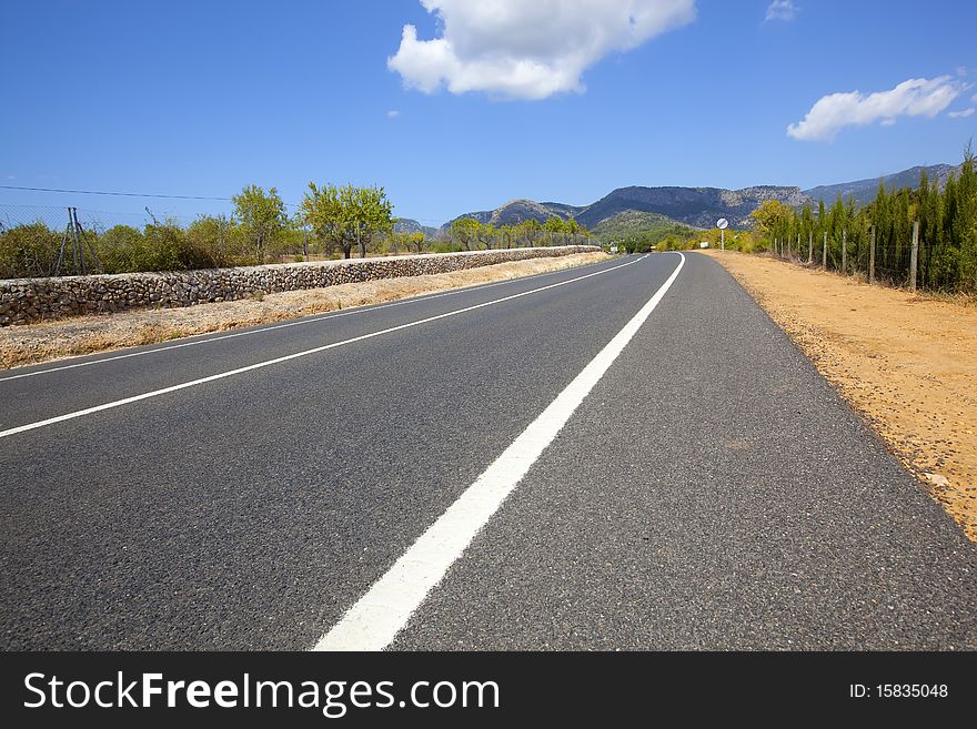 Straight highway road across non-urban landscape with blue sky and clouds. Straight highway road across non-urban landscape with blue sky and clouds