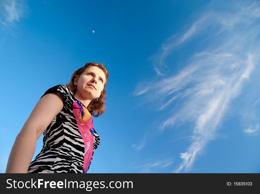 A beautiful girl on a background of blue sky. A beautiful girl on a background of blue sky