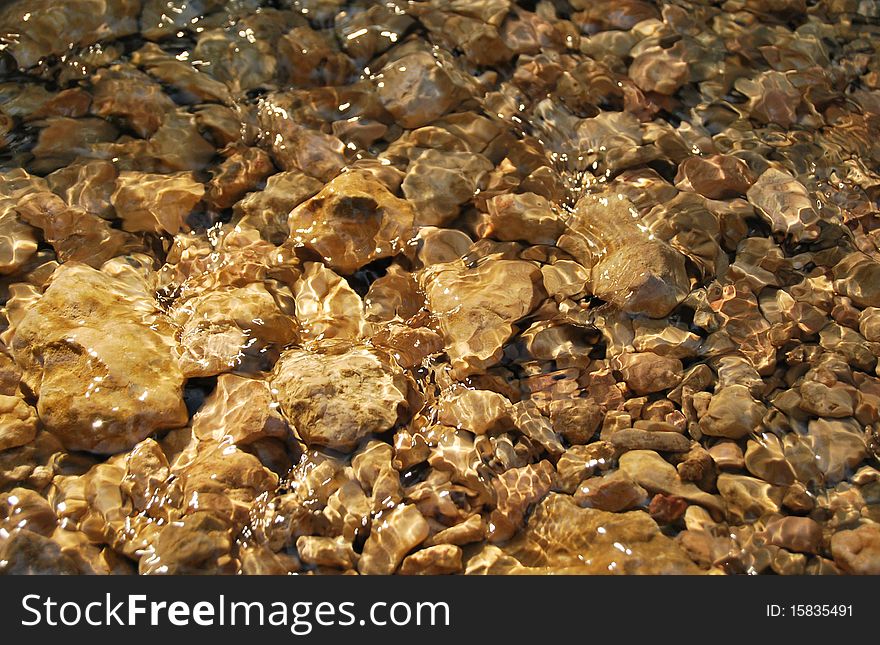 Stones under water in a sunny day