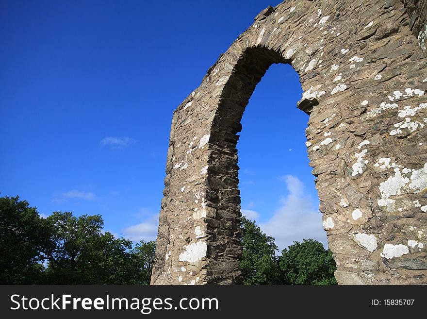 Ancient stone archway against a brilliant blue sky