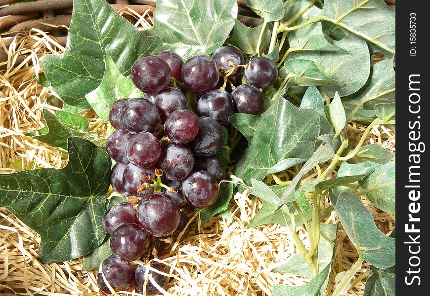 Bunch of grapes in the basket with straw