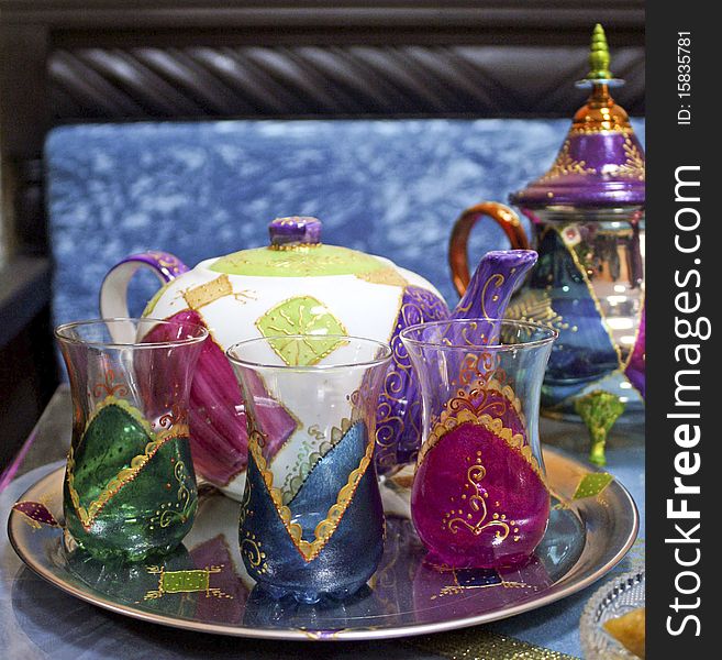 Two Moroccan teapots and three cups on a tray. Two Moroccan teapots and three cups on a tray