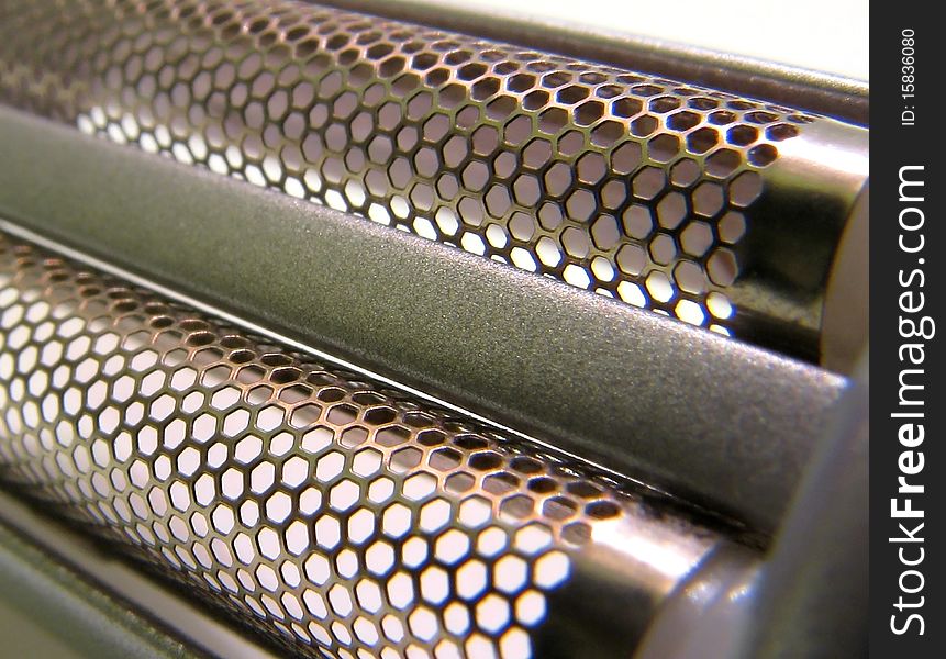 Close up photo of a shavers twin micro foil head showing detailed honeycomb pattern. Close up photo of a shavers twin micro foil head showing detailed honeycomb pattern.