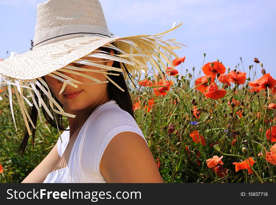 Young beautiful woman in poppy flowers