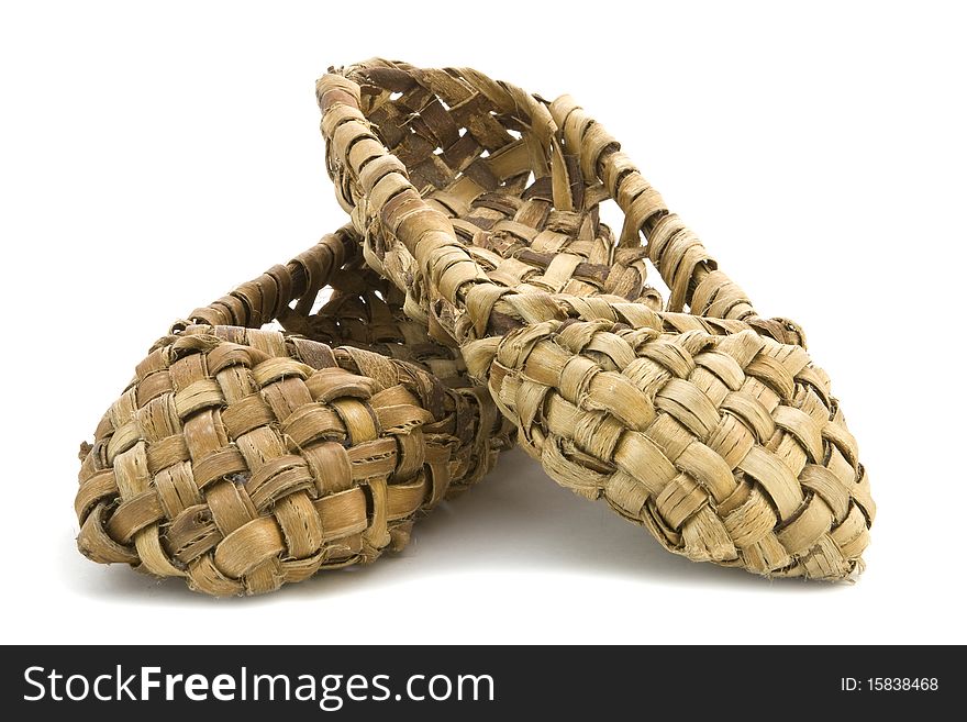 An old peasant shoes on a white background. An old peasant shoes on a white background.