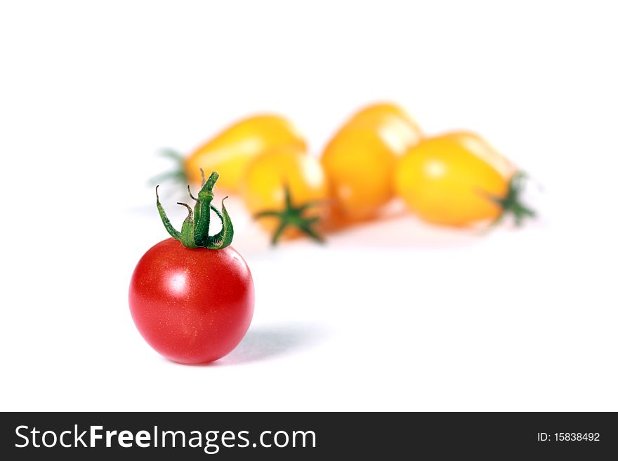 Red tomato against yellow tomatoes. Concept